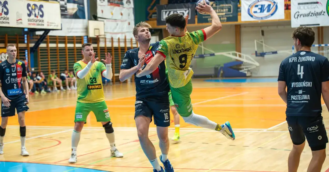 Jakub Wojnowski w akcji podczas meczu piłki ręcznej. Zawodnik w żółto-zielonej koszulce z numerem 9 próbuje rzucić piłkę do bramki, broniony przez przeciwnika.