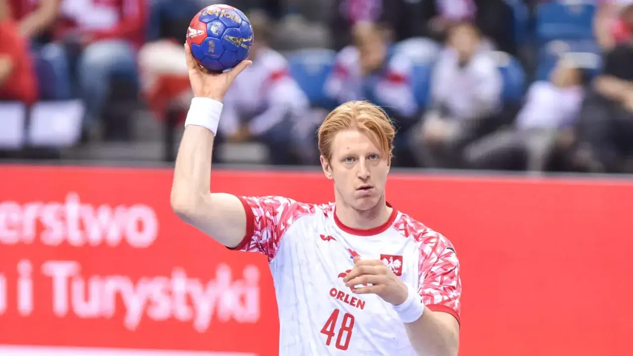 Tomasz Gębala, zawodnik z numerem 48 na koszulce, przygotowuje się do rzutu piłką ręczną.