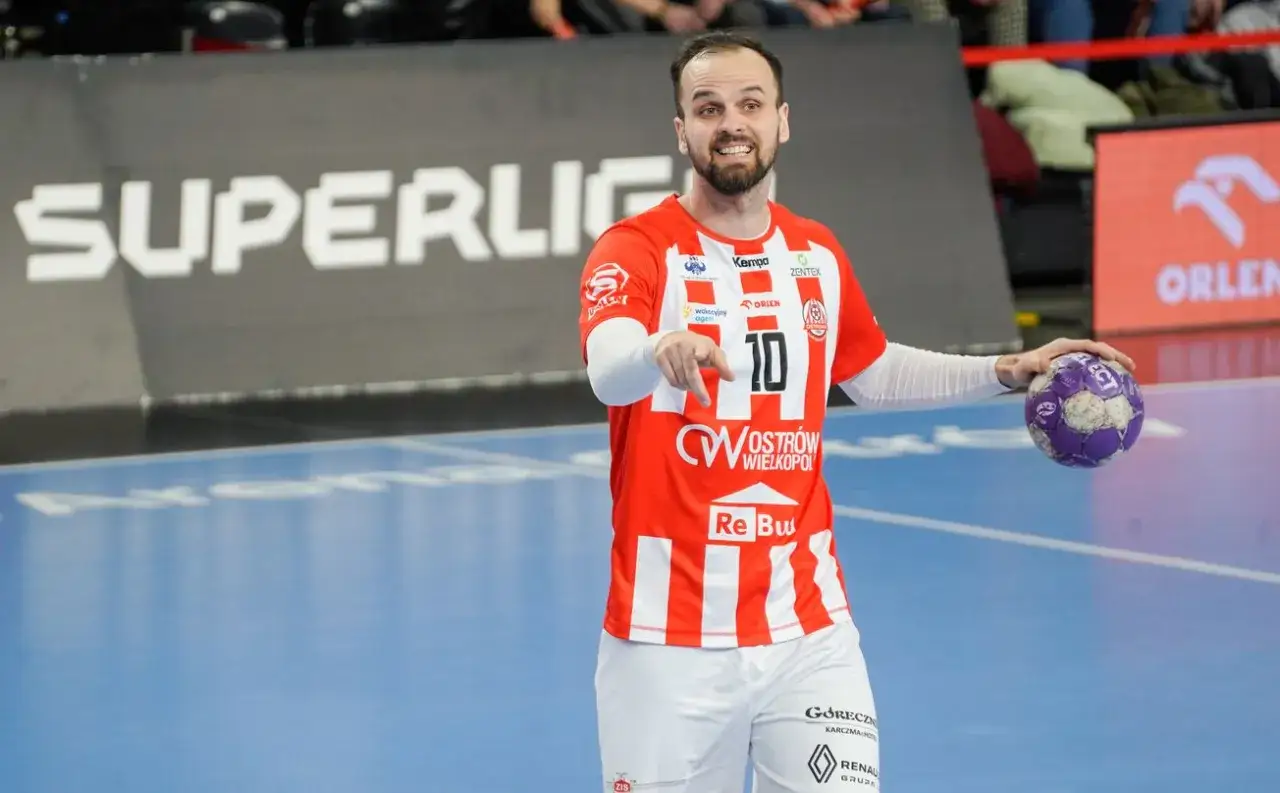 Krzysztof z numerem 10 na koszulce, z piłką w dłoni, wskazuje palcem na boisku.