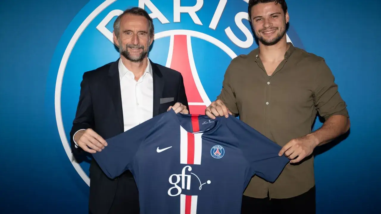 Dwóch mężczyzn prezentuje koszulkę PSG. Jeden z nich, z siwiejącą brodą, ubrany jest w garnitur. Drugi, młodszy, w zielonej koszuli, uśmiecha się. To może być moment, gdy elohim prandi dołączył do klubu.