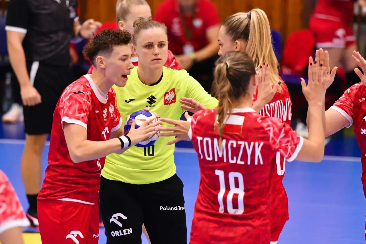 Piłkarki ręczne Polski w czerwonych strojach z orłem na piersiach, w skupieniu przed meczem ze Szwecją.