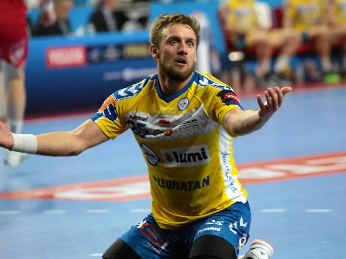 Luka Cindrić w żółtej koszulce z niebieskimi detalami, w akcji na boisku.
