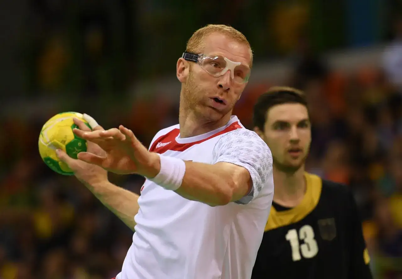 Kamil Bielecki w okularach ochronnych rzuca piłką do ręcznej.