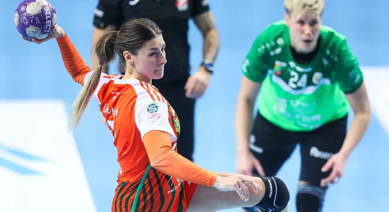 Piłkarka ręczna w pomarańczowej koszulce szykuje się do rzutu. Emocje na parkiecie podczas meczu final four handball.