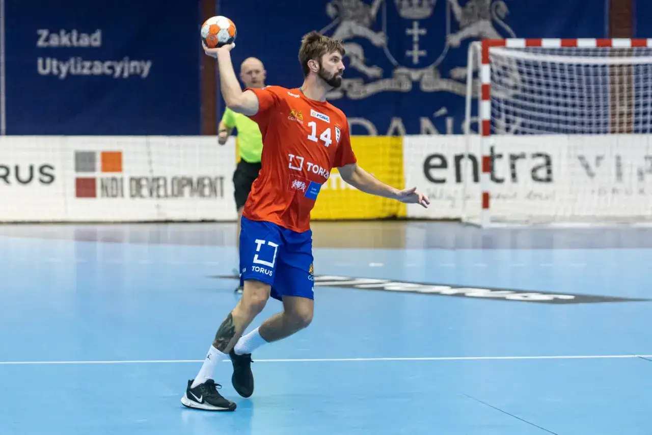 Artur Sadowski w akcji, rzuca piłkę do bramki.