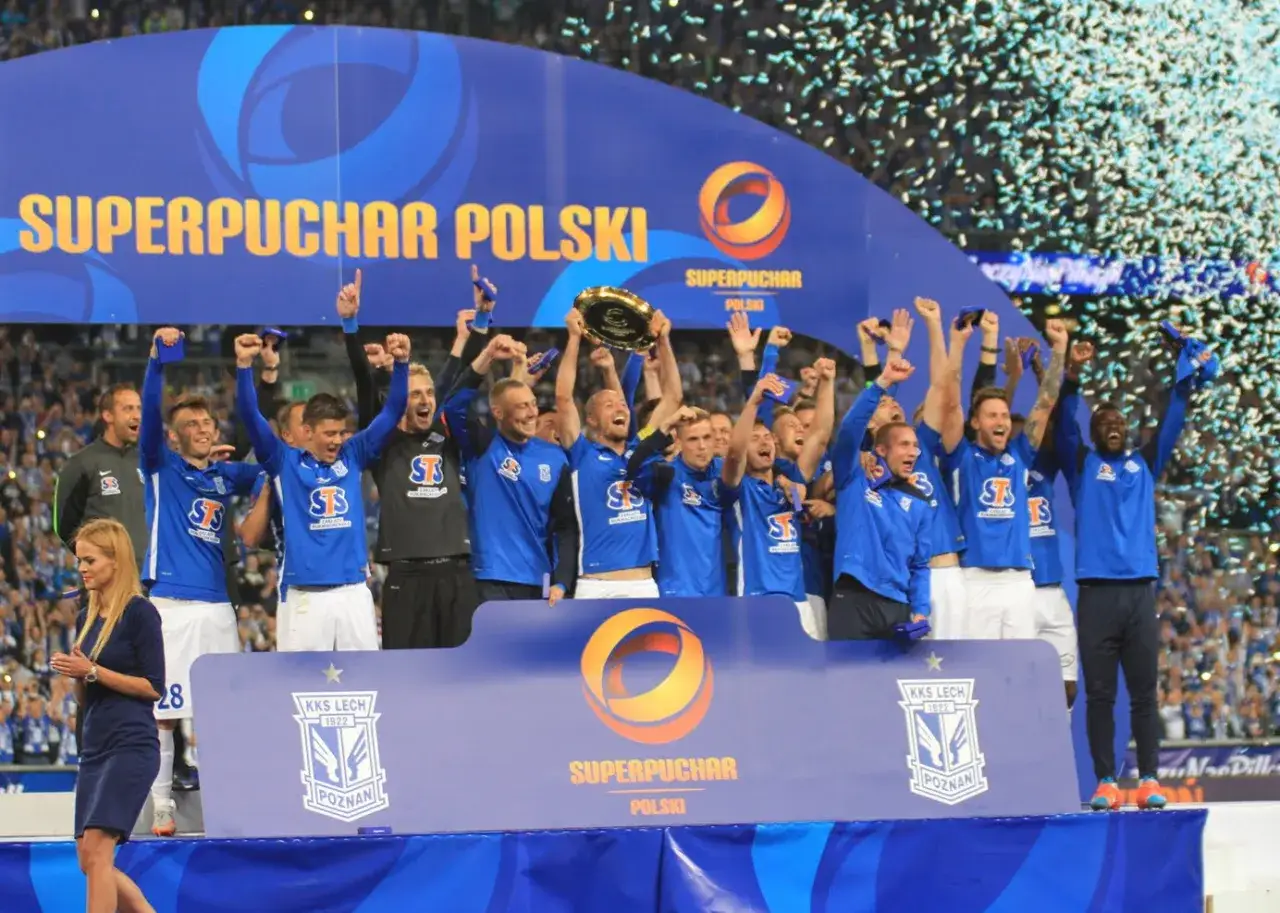 Piłkarze świętują zdobycie Superpucharu Polski, unosząc trofeum i ciesząc się z wygranej wśr&oacute;d konfetti.