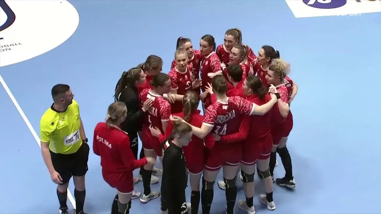 Drużyna piłki ręcznej Polska w czerwonych strojach tworzy kółko wsparcia.