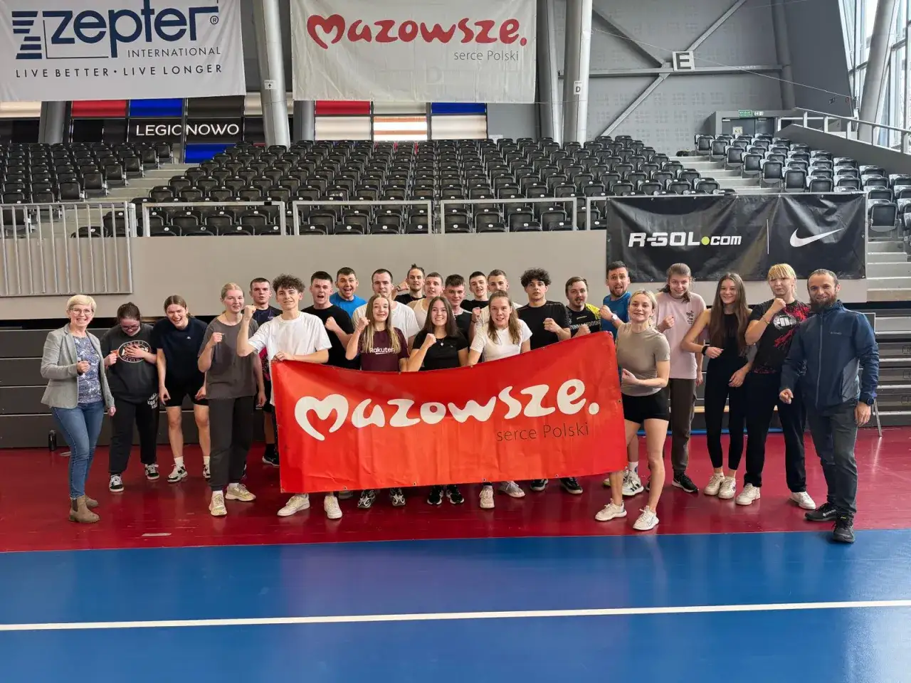 Grupa młodych ludzi z KPR Legionowo pozuje z banerem