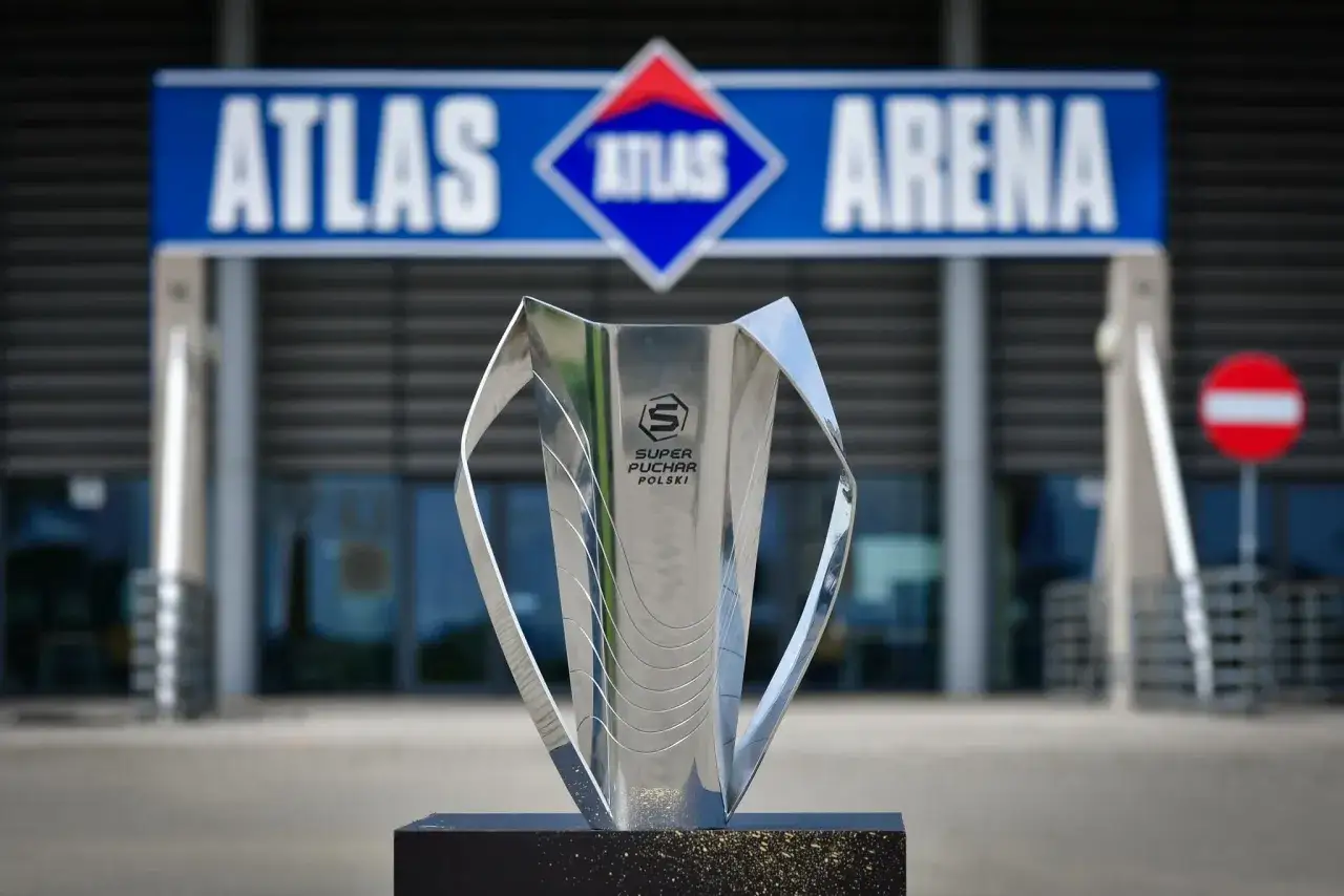 Trofeum Super Pucharu Polski błyszczy przed Atlas Areną, symbolizując triumf i sportowe emocje.