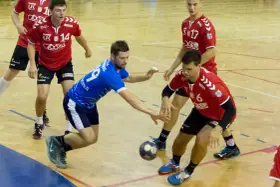 Piłkarze ręczni SPR Wisła Sandomierz walczą o piłkę na boisku.